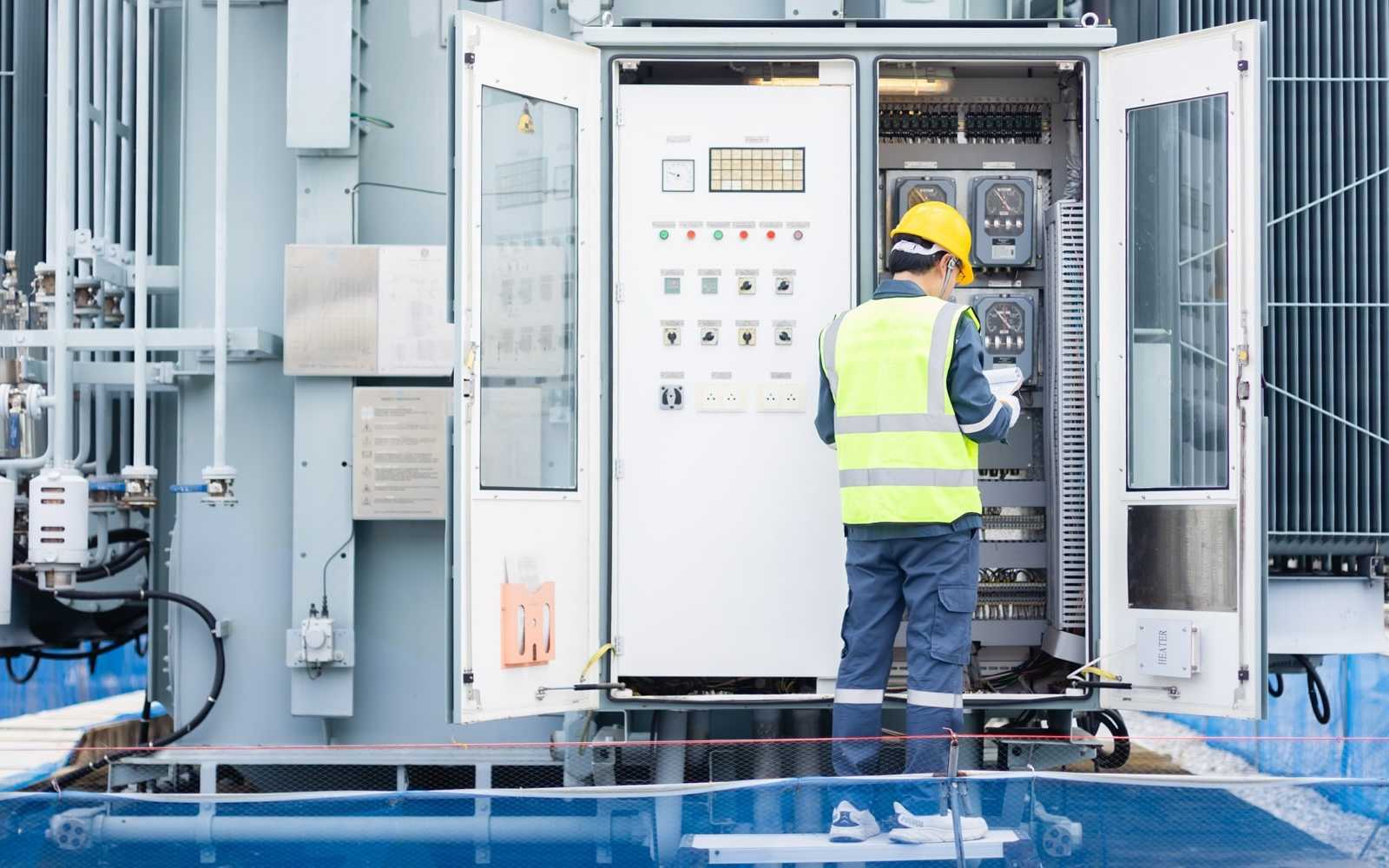 engineer assesses an industrial panel at a power plant